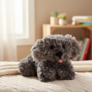 May include: A plush, gray dog toy with a fluffy texture. The toy has black eyes, a black nose, and a pink tongue sticking out. It is lying down on a cream-colored, textured blanket. The dog toy is a cute and cuddly item.