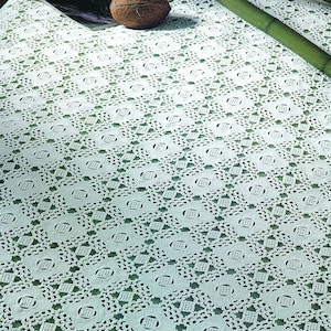 May include: White crochet bedspread with a diamond pattern, displayed on a bed with bamboo poles and a brown pillow.  © 2024 Vintage Stitchery Archives