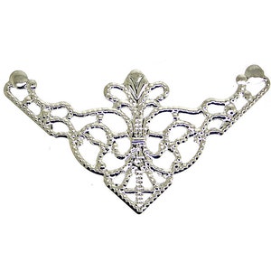 May include: A silver-colored, filigree metal corner bracket with an ornate, symmetrical design. The bracket features a central floral motif and delicate, openwork patterns, perfect for decorative applications. The bracket is approximately 3 inches wide.