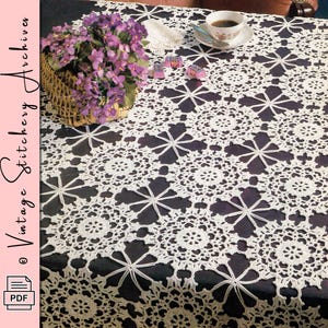 May include: A white, crocheted tablecloth with a floral pattern is displayed on a table. A basket of purple flowers, a teacup, and small decorative items are on the table. The image has the text "Vintage Stitchery Archives" and a PDF icon.