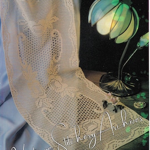 Può includere: Un runner da tavolo all'uncinetto con un delicato motivo a pizzo. Il runner è beige e ha un aspetto vintage. L'immagine include il testo "Vintage Stitchery Archives".