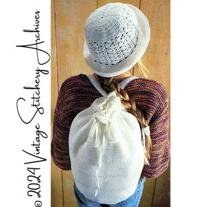 May include: A white crocheted backpack with a drawstring closure. The backpack is being worn by a person with a white crocheted hat and a colorful striped sweater.