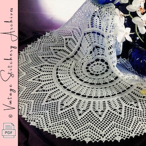 May include: A white, intricately crocheted doily with a circular design. The doily features a detailed pattern of openwork and geometric shapes. The image also includes a vase of white orchids and the text "Vintage Stitchery Archives" and a PDF icon.
