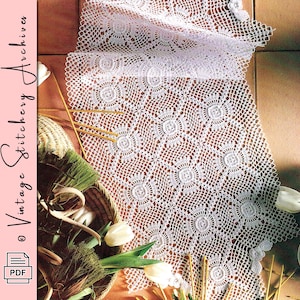 May include: A white, crocheted table runner with a floral pattern. The runner is displayed on a brown surface, with a basket of greenery and white tulips in the foreground. The text "Vintage Stitchery Archives" is visible.