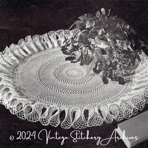 May include: A white crocheted doily with a scalloped edge and a delicate floral design. The doily is large enough to hold a potted plant.