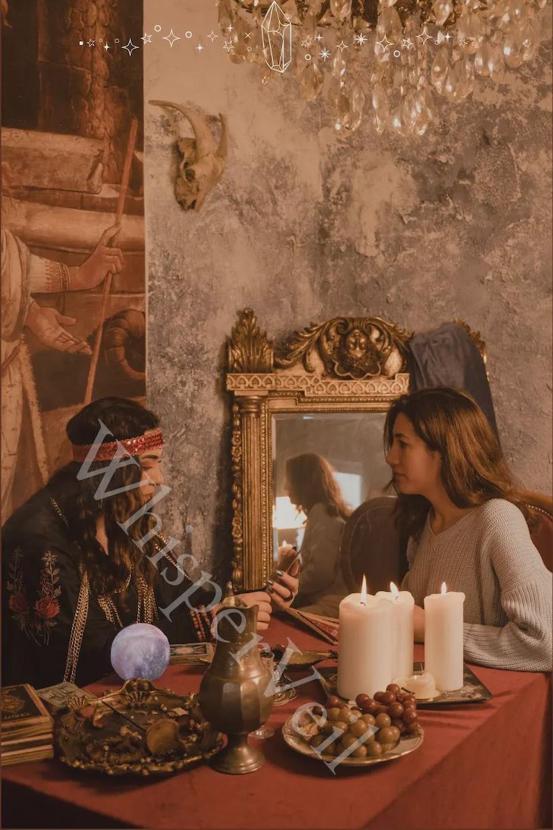 Puede incluir: Imagen atmosf&eacute;rica de dos personas sentadas a una mesa roja, en un entorno m&iacute;stico. La escena incluye velas, un espejo decorativo y un recipiente de lat&oacute;n. La palabra "Whisperveil" es parcialmente visible.