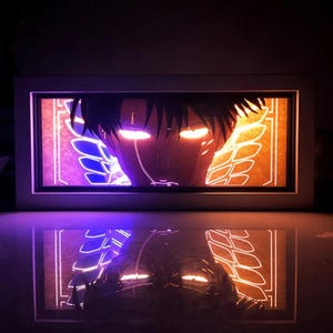Könnte beinhalten: Gerahmtes Kunstwerk mit einem Anime-Charakter mit leuchtenden Augen. Der Hintergrund zeigt flügelartige Designs, und das Bild spiegelt sich auf der darunter liegenden Oberfläche. Das Kunstwerk ist in Orange- und Lilatönen beleuchtet.