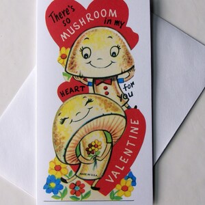 K&ouml;nnte beinhalten: Eine Valentinstagskarte mit zwei l&auml;chelnden Cartoon-Pilzen. Die Karte hat ein rotes Herz mit dem Text "There's so mushroom in my heart for you Valentine." Bunte Blumen umgeben die Pilze.