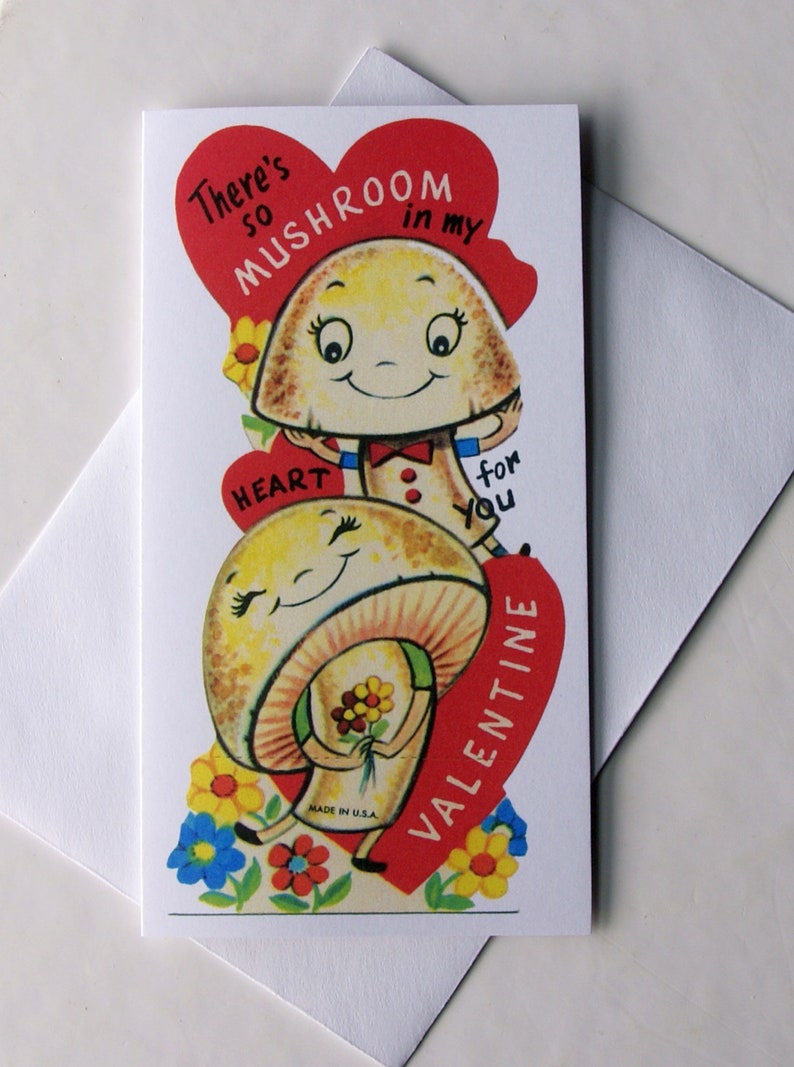 K&ouml;nnte beinhalten: Eine Valentinstagskarte mit zwei l&auml;chelnden Cartoon-Pilzen. Die Karte hat ein rotes Herz mit dem Text "There's so mushroom in my heart for you Valentine." Bunte Blumen umgeben die Pilze.