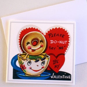 May include: A vintage Valentine's Day card with a smiling donut character in a teacup. The card has a red heart with the text "PLEASE DO-NUT SAY 'NO' BE MY VALENTINE". The teacup is yellow with a blue handle and saucer.
