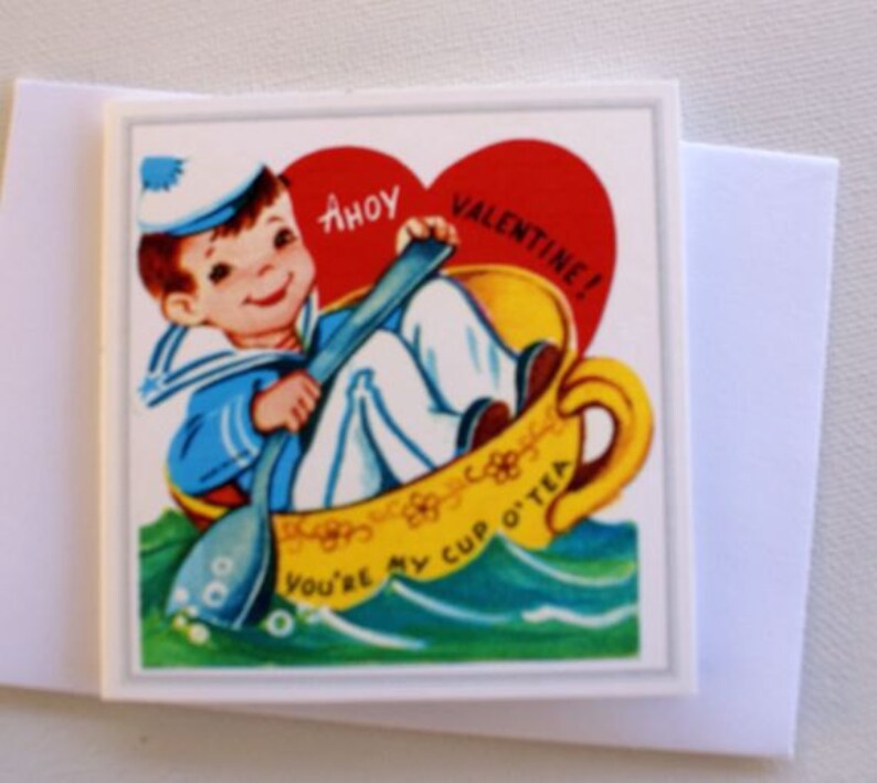 May include: A vintage Valentine's Day card with a cartoon sailor in a teacup. The card reads "Ahoy Valentine! You're my cup o' tea." The sailor is in a blue and white uniform, and the teacup is yellow with a red heart.