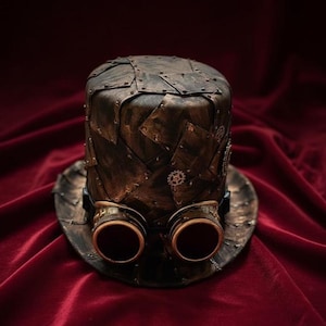 Könnte beinhalten: Ein Steampunk-Zylinderhut in Bronzeoptik, verziert mit genieteten Metallplatten und integrierter Schutzbrille. Der Hut hat eine breite Krempe und ist mit kleinen Zahnrädern verziert.