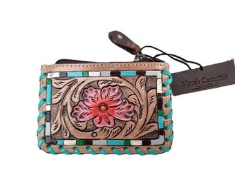 May include: Tan leather wallet with a floral design. The wallet features a pink flower with a red center, surrounded by carved leaves. The edges are stitched with turquoise thread, and the tag reads "Maya's Curiosities".