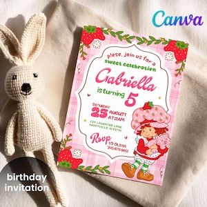 May include: A birthday invitation with a pink plaid background, featuring a Strawberry Shortcake character. The invitation reads "Gabriella is turning 5" and includes event details. A crocheted bunny doll is next to the invitation.