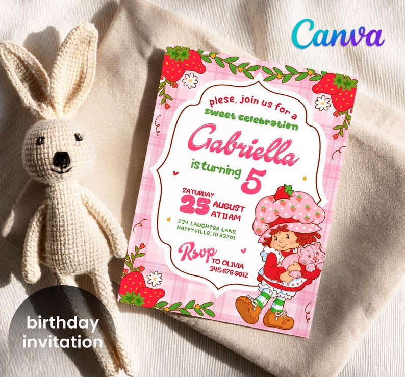 May include: A birthday invitation with a pink plaid background, featuring a Strawberry Shortcake character. The invitation reads "Gabriella is turning 5" and includes event details. A crocheted bunny doll is next to the invitation.