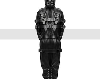 Puede incluir: Un traje de cuero negro con capucha y múltiples correas y hebillas. La capucha tiene aberturas para los ojos y la boca. El traje está diseñado para cubrir todo el cuerpo, con detalles de cordones en los pies.