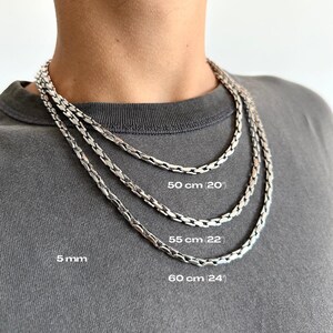 May include: Three silver chain necklaces of varying lengths: 50 cm, 55 cm, and 60 cm. The chains are 5 mm thick and are displayed around a person's neck. The lengths are labeled in the image.