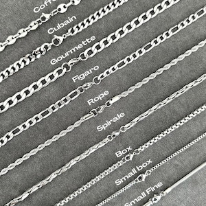 Pode incluir: Uma coleção de correntes de metal prateado rotuladas com o texto Coffee, Cubain, Gourmette, Figaro, Rope, Spirale, Box, Small box e Small Fine. Cada corrente apresenta um padrão de elos distinto e um fecho tipo lagosta.