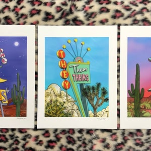May include: Three retro-style motel signs with desert landscapes in the background. The signs read "Her Hers", "They Them Theirs", and "He Him His".