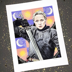 May include: A woman in black armor holds a sword, standing in front of a colorful shield with a wolf and a star design. The shield is a heraldic symbol with a blue, purple, and white background.