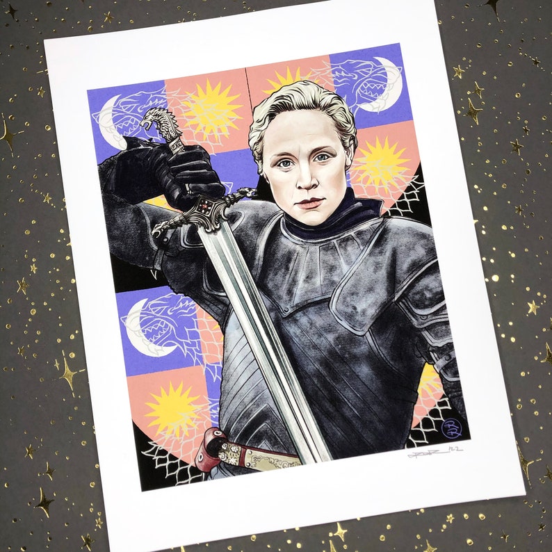 May include: A woman in black armor holds a sword, standing in front of a colorful shield with a wolf and a star design. The shield is a heraldic symbol with a blue, purple, and white background.