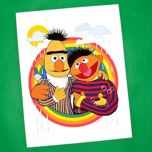 May include: A colorful illustration of two Sesame Street characters, Big Bird and Elmo, standing together in front of a rainbow. Big Bird is wearing a striped shirt and Elmo is wearing a striped shirt with a yellow rubber ducky. The background is a rainbow with rain falling from the sky.
