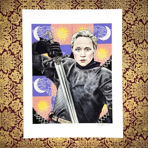 May include: A woman in black armor holds a sword with a silver blade. She is standing in front of a colorful background with a pattern of stars and moons. The background is a shield with a design of a wolf, a star, and a moon.