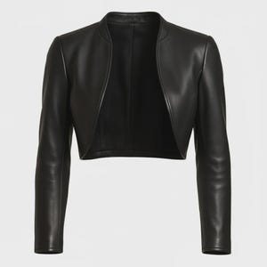 May include: A black leather bolero jacket with long sleeves. The jacket has a round neckline and an open front design. The leather appears smooth and has a slight sheen. The jacket is a cropped style, ending at the waist.