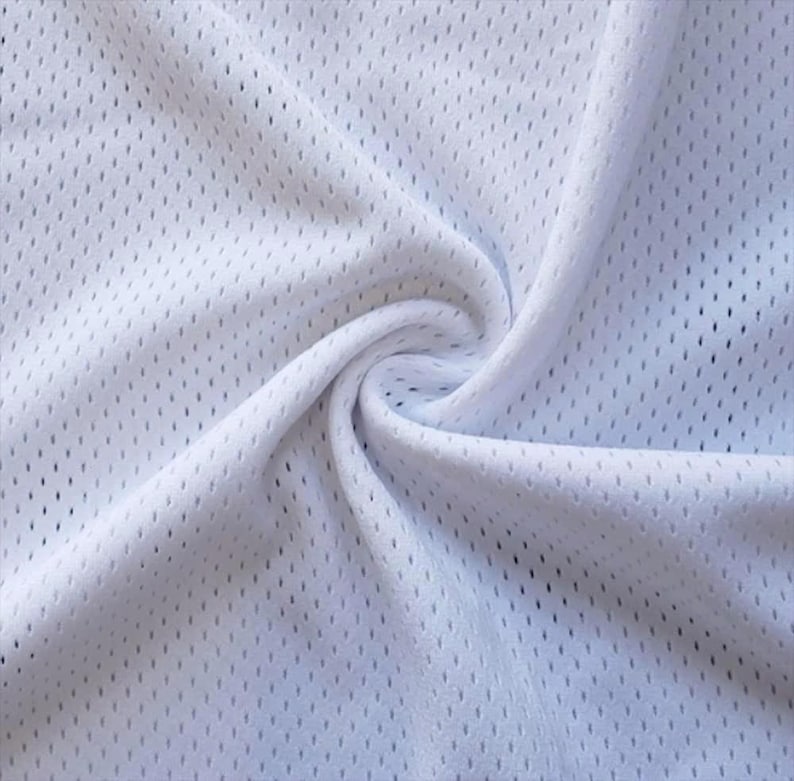 May include: Close-up of white athletic mesh fabric with small, evenly spaced holes. The fabric is gathered and swirled, creating soft folds and shadows. The material appears lightweight and breathable.