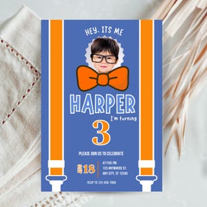 May include: A birthday invitation with a blue background and orange accents. The invitation features the name "Harper" and the number "3". The text "Hey, It's Me" is at the top, and the date is August 18th. A photo of a child wearing glasses and a bow tie is in the center.