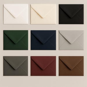 May include: Nine square envelopes in various colors, including white, cream, black, dark green, navy, gray, dark gray, burgundy, and brown. The envelopes are arranged in a three-by-three grid, showcasing their different hues and textures.