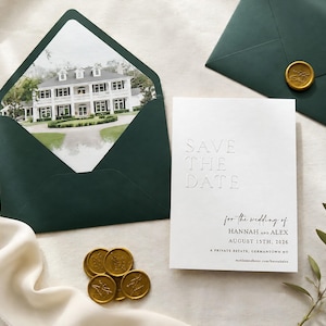 May include: A wedding invitation suite featuring a white card with embossed text reading "SAVE THE DATE" and details for Hannah and Alex's wedding. The suite includes a dark green envelope, a matching envelope liner with a house image, and gold wax seals.