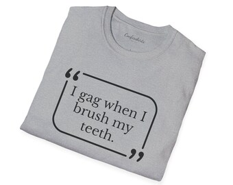 May include: A light gray t-shirt with the text "I gag when I brush my teeth" in a black speech bubble. The shirt has a crew neck and the brand name "Confesshirts" is visible.