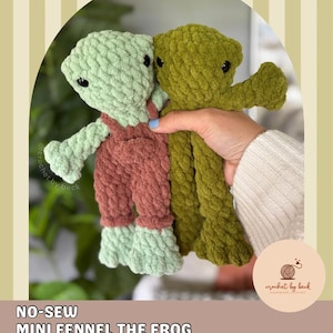 May include: Two plush crochet frog toys made from soft yarn. One frog is light green wearing brown overalls, and the other is olive green. The image includes the text @crochet.by.beck, NO-SEW MINI FENNEL THE FROG, and DIGITAL DOWNLOAD CROCHET PATTERN.