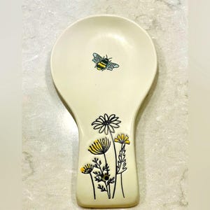 Trendy Ceramic Spoon Rest with Bumblebee and Daisies Design, holds your cooking spoons and serving spoons and keep your countertops clean!