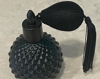 May include: Black vintage perfume bottle with a textured, diamond-patterned glass base. The bottle has a black bulb atomizer with a matching tassel. The design is reminiscent of antique apothecary bottles.