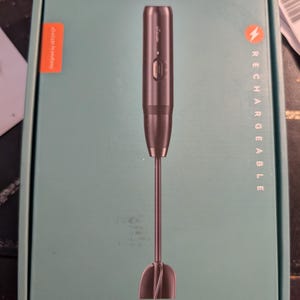 Puede incluir: Un mezclador de resina recargable de Istoyo, con el texto "Rechargeable Resin Mixer" en la caja. El mezclador es gris oscuro con un cabezal mezclador en forma de paleta. La caja es verde azulado con el texto "Free Your Hands!"