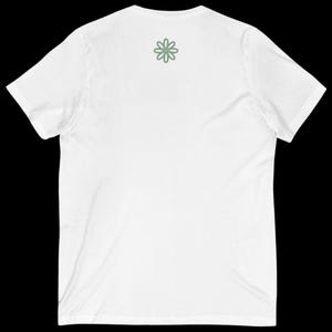 Puede incluir: Camiseta blanca con cuello en V y mangas cortas. Un dise&ntilde;o floral verde claro est&aacute; en la parte superior de la espalda. La camiseta est&aacute; hecha de un material suave y ligero, ideal para el uso diario.