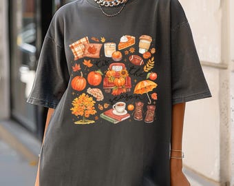 May include: Dark gray t-shirt with a colorful fall-themed graphic. The design includes pumpkins, a red truck, leaves, a slice of pie, coffee, and the text "Kiss the season."