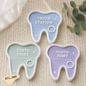 May include: Three tooth-shaped signs in pastel blue, green, and purple. Each sign has white trim and text: "TOOTH STATION", "TOOTH FAIRY Please Stop Here", and "TOOTH FAIRY My First Tooth". Decorative star and circle details.