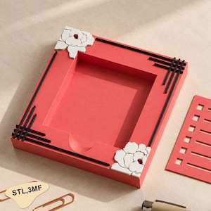 May include: A rectangular coral-colored tray with a recessed center, featuring white floral relief accents on two corners and black linear grid patterns on the other two corners. The text "STL,3MF" is printed on a small beige tag nearby.
