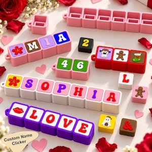 May include: A collection of modular plastic clicker blocks in various colors, featuring letters spelling MIA, SOPHIA, and LOVE, along with numbers 2, 4, 6, and icons like a flower, cow, gingerbread man, stocking, ghost, and ampersand symbol.