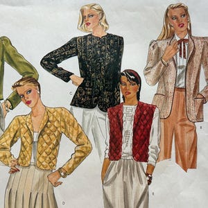 May include: Vogue's Basic Design sewing pattern featuring illustrations of five different jacket and vest styles. The jackets are in various colors and patterns, including green, black, and gold. The pattern includes the number 2799.