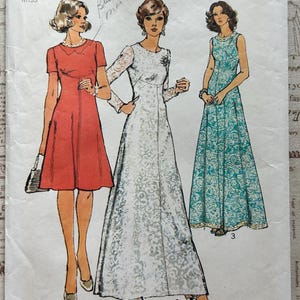 May include: Vintage Simplicity sewing pattern, featuring three dress designs. The pattern includes a red dress, a white lace gown, and a turquoise floral print dress. The pattern is size 14, with a 36-inch bust.