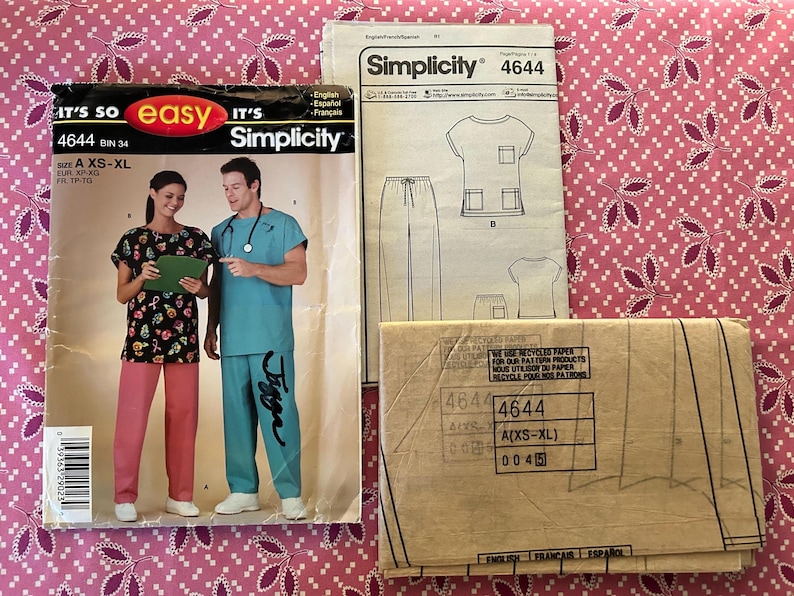May include: Simplicity sewing pattern 4644 for scrubs. The pattern includes images of scrubs and the words "It's so easy" and "Simplicity". The pattern is for sizes XS-XL. The image also includes a photo of a person wearing scrubs.