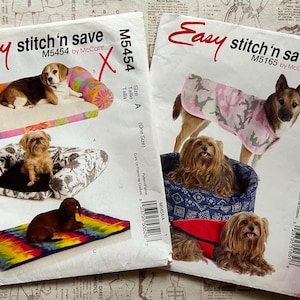 May include: Two sewing pattern envelopes for pet accessories. One shows a dog on a bed with a pink and orange floral design. The other shows a dog wearing a pink camouflage coat. The text "Easy stitch'n save" is visible.