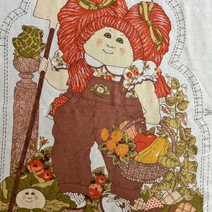 May include: A vintage Cabbage Patch Kids fabric panel featuring a doll with red hair, wearing brown overalls and holding a shovel. A basket of produce and a frog on a pedestal are also shown. The text "LEAVE OPEN FOR STUFFING" is at the bottom.