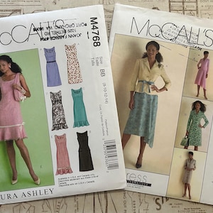 May include: Two McCall's sewing pattern envelopes. One features a pink dress and the text "LAURA ASHLEY". The other shows a woman in a yellow jacket and skirt. Both patterns include illustrations of various dress designs.