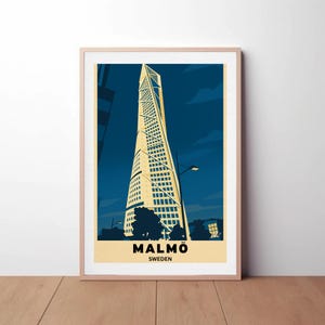 Puede incluir: Una impresión artística enmarcada que presenta una ilustración estilizada del rascacielos Turning Torso en Malmö, Suecia. La obra de arte utiliza una paleta de colores azul, crema y amarillo. El texto "MALMÖ SWEDEN" está en la parte inferior.