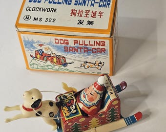 May include: A vintage wind-up toy featuring Santa Claus in a sleigh pulled by a dog. The toy is in its original box, which reads "DOG PULLING SANTA-CAR" in English and Chinese. The toy is made of metal and painted in bright colors.